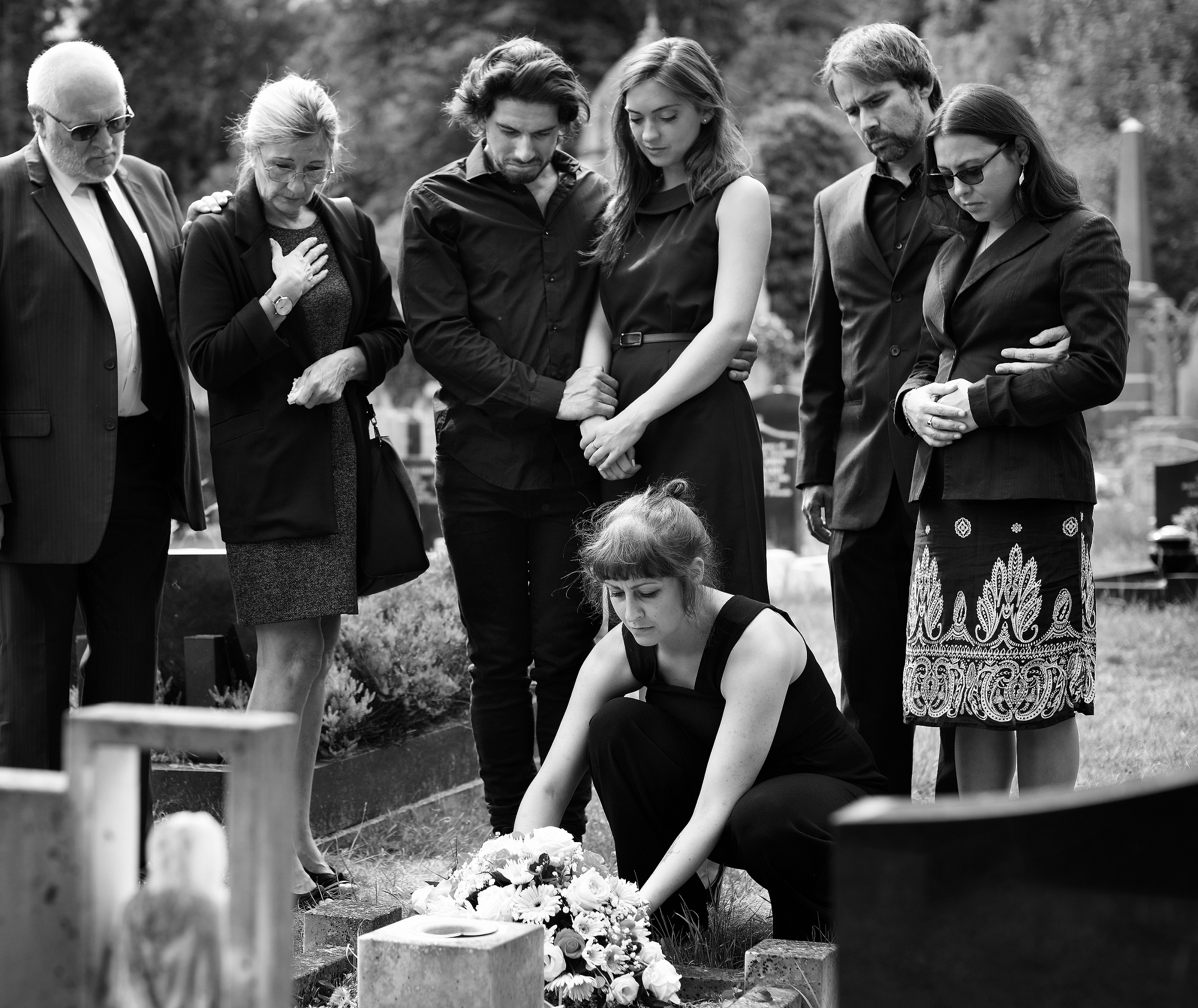 Family laying flowers on the grave