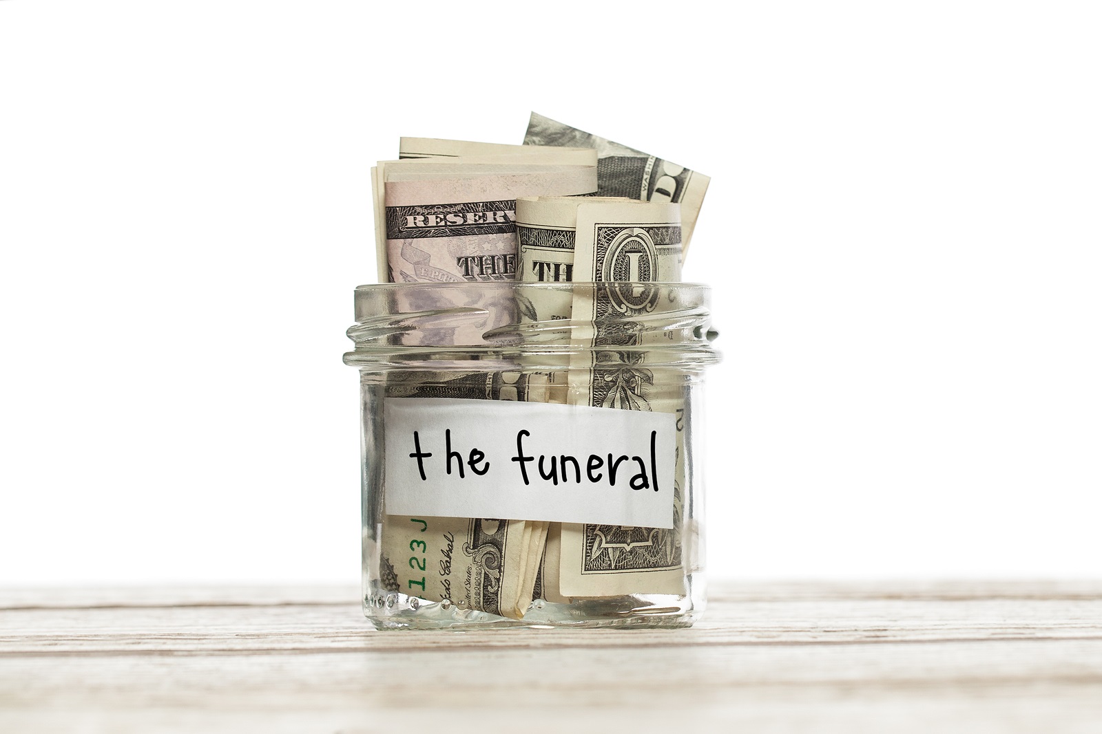 Save Download Preview Saving jar with money for the funeral on white wooden table