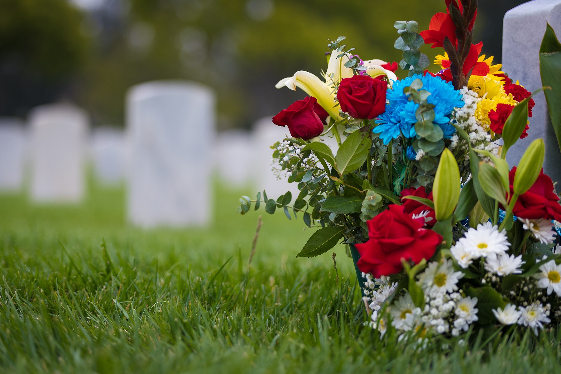 Save Download Preview white grave markers and flowers at a national cemetery
